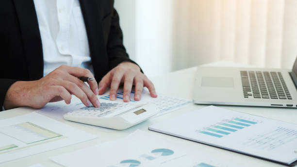 istock Business people working on desk and analysis about summary budget finance and using laptop making note report. 1311014862