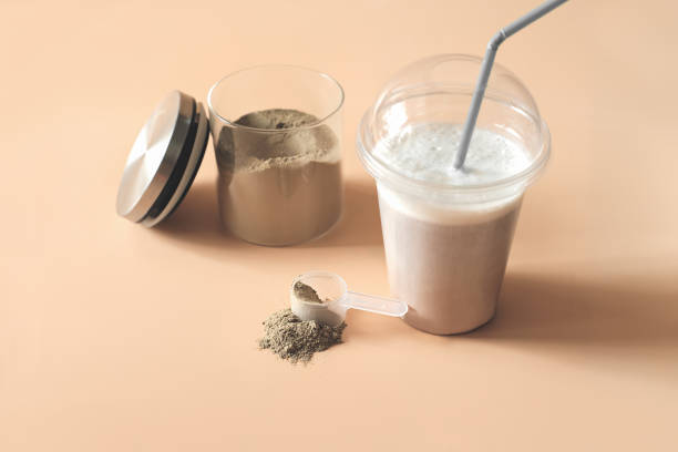 istock whey drink in plastic cup and a jar with chocolate protein powder and a scoop on a table. protein supplement for healthy muscle building and athletic nutrition 1311018587