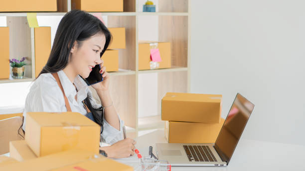 istock Attractive young Asian startups look at camera work happily at home boxes, preparing package delivery in sme supply chain, purchasing, omnichannel purchasing, online selling concept. 1311021966