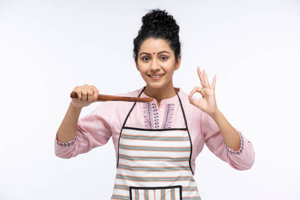 retrato de mujeres jóvenes chef degustando la sopa de verduras sosteniendo cuchara de madera de pie aislado sobre fondo blanco:- foto de archivo - comida hindú fotos fotografías e imágenes de stock