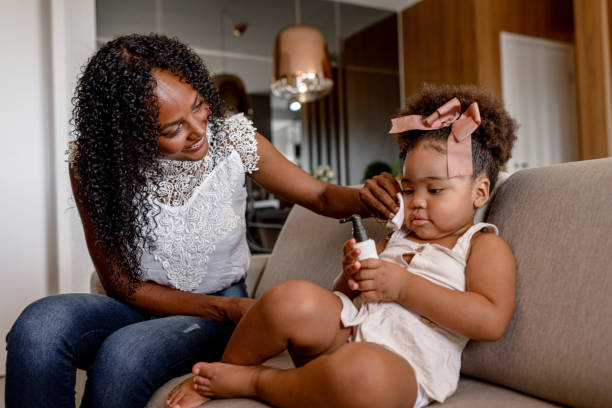 istock Mother using makeup remover on her daughter sitting on the sofa 1311033005