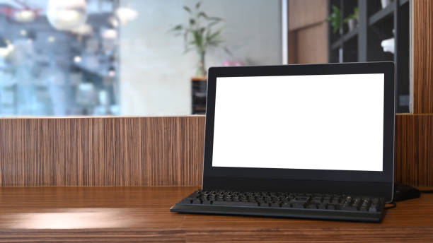 istock Mock up computer with blank screen on wooden table in office. 1311033062