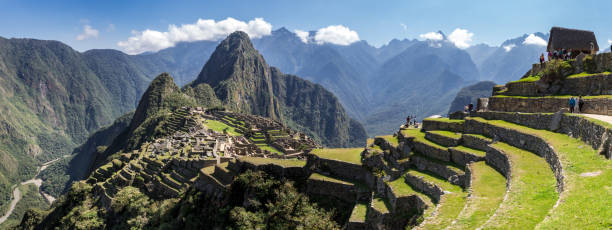 Panoramic view of Machu Picchu ruins in Peru Panoramic view of Machu Picchu ruins in Peru. Behind we can appreciate big and beautiful mountains full of green vegetation. Archaeological site, UNESCO World Heritage inca photos stock pictures, royalty-free photos & images