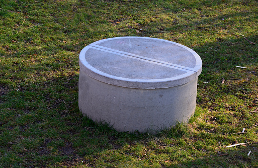 concrete well of the well covered with a round concrete lid. the hatch is heavy so that children cannot open it. a fall into a well often ends tragically with drowning, suffocation, or fractures.
