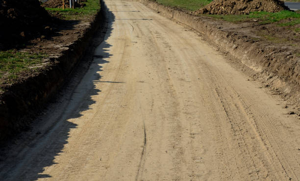 istock a new path through the fields. an excavator and a grader drove the way through a spade and rolled the topsoil into piles and a recycled concrete recycled material from the demolition of buildings 1311037131