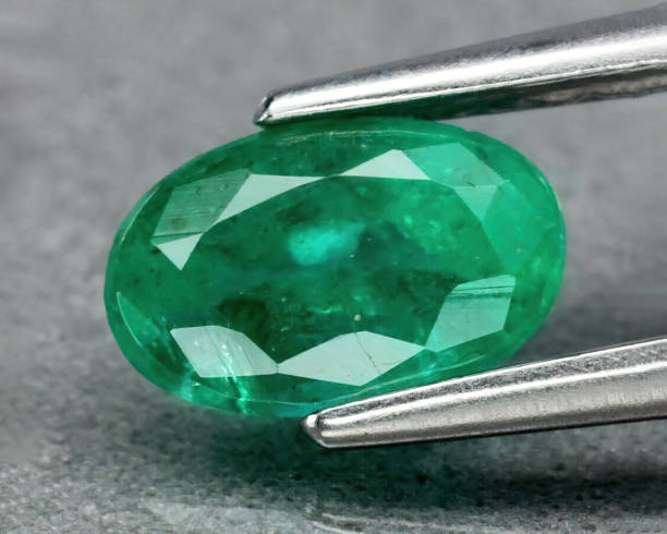 istock Natural gemstone green emerald on gray background 1311038955