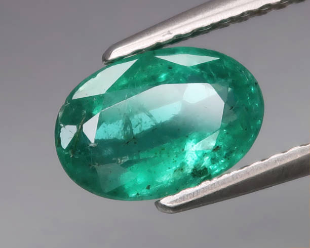 istock Natural gemstone green emerald on gray background 1311038958