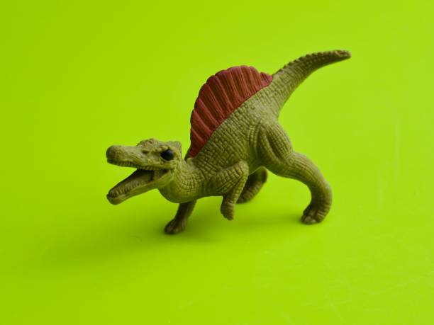 istock Spinosaurus figure against green background 1311041030