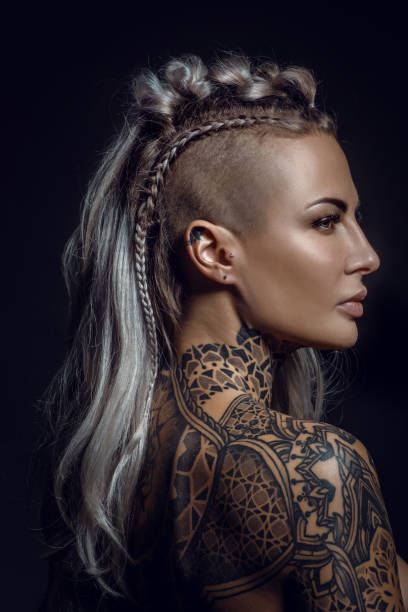 Side portrait of a tattooed viking blonde female and her unique hairstyle Side portrait of a tattooed viking blonde female and her unique hairstyle hair length stock pictures, royalty-free photos & images