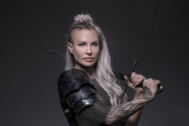 istock Sword wielding viking warrior blonde female in studio shot 1311042374