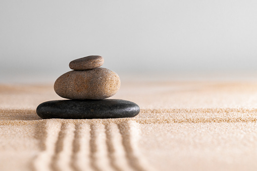 Japanese zen garden with stone in raked sand, close up.