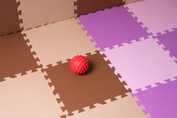 Red rubber ball on foam floor tile