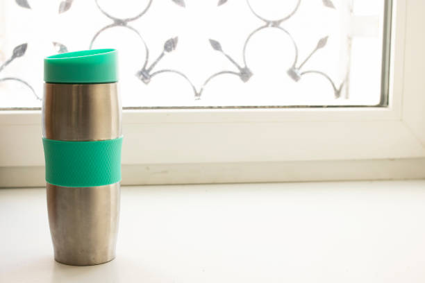 istock Metal thermo mug on windowsill in sunlight 1311044901