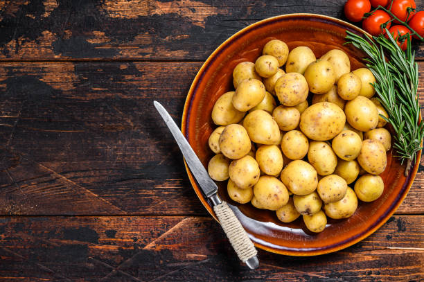 istock Raw baby mini Potatoes. Dark wooden background. Top view. Copy space 1311046175
