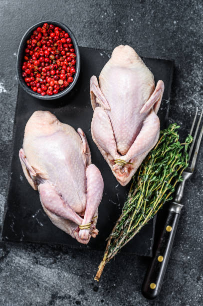 istock Farm eco friendly raw quails ready for cooking. Black background. Top view 1311047358