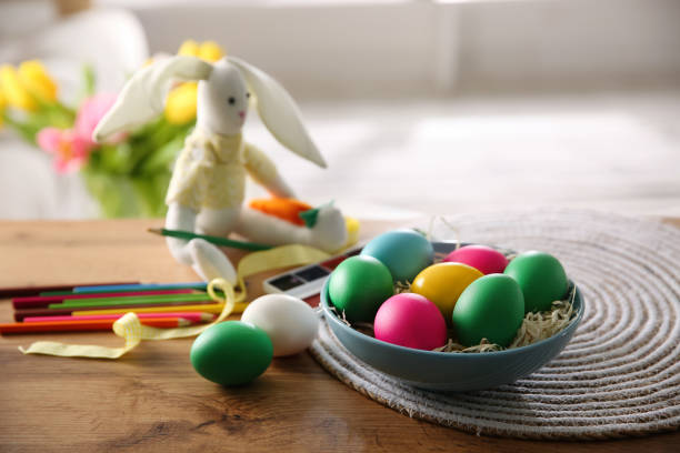 istock Bright painted Easter eggs, color pencils and toy bunny on wooden table indoors 1311047509
