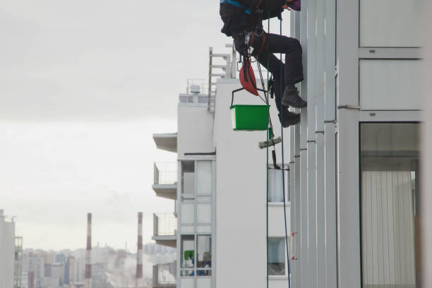 istock Industrial mountaineering worker hangs over residential facade building while washing exterior facade glazing 1311047865