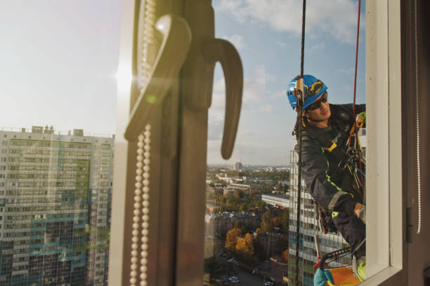 istock Industrial mountaineering worker hangs over residential facade building while washing exterior facade glazing 1311047922