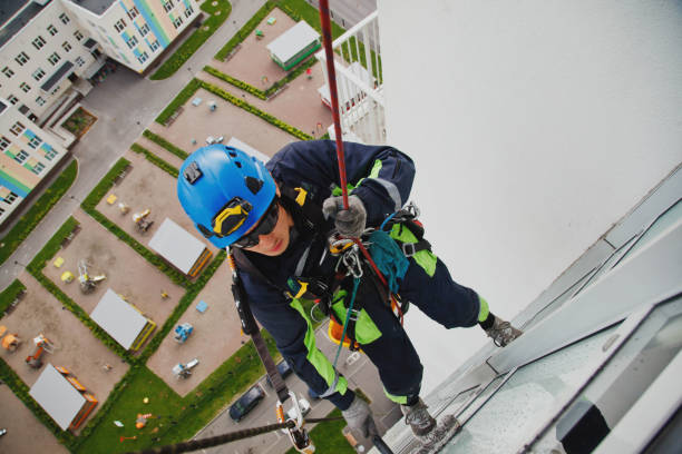 istock Industrial mountaineering worker hangs over residential facade building while washing exterior facade glazing 1311047923