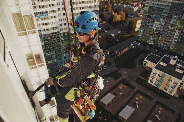 istock Industrial mountaineering worker hangs over residential facade building while washing exterior facade glazing 1311047935