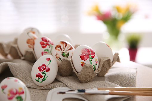 Beautifully painted Easter eggs on table indoors