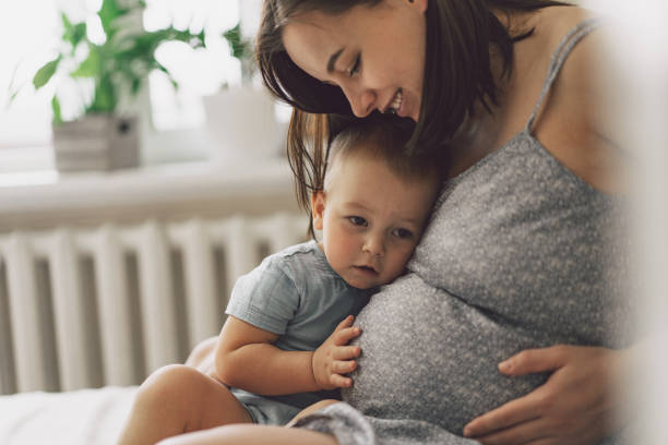young woman with her first child during second pregnancy. motherhood and parenting concept. - human pregnancy prenatal care women abdomen imagens e fotografias de stock