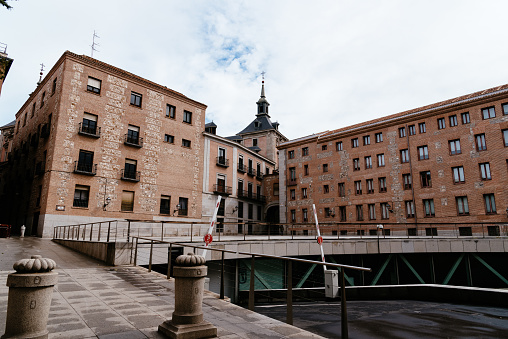 Madrid, Spain - April, 2, 2021: Former City Hall of Madrid and municipal subway parking from Sacramento street. Empty square during pandemic of Covid-19 in Easter week