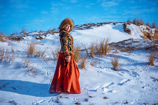 Beautiful elegant young blonde Russian woman outside in the snow in the dutch countryside