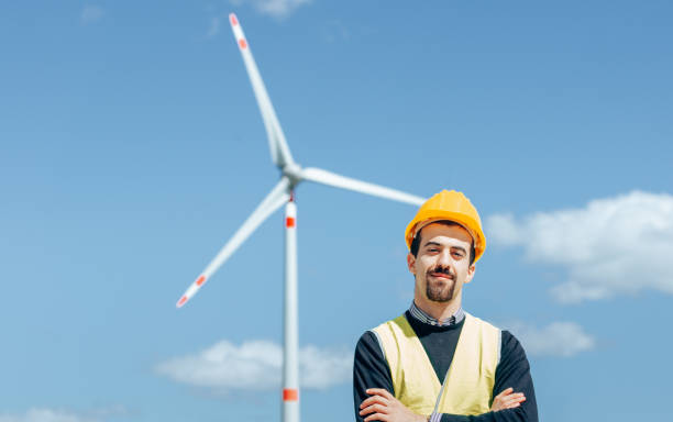 istock confident engineer against the wind turbine 1311051531