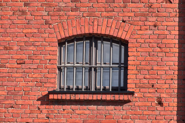 istock The old prison window on the red brick wall 1311052106