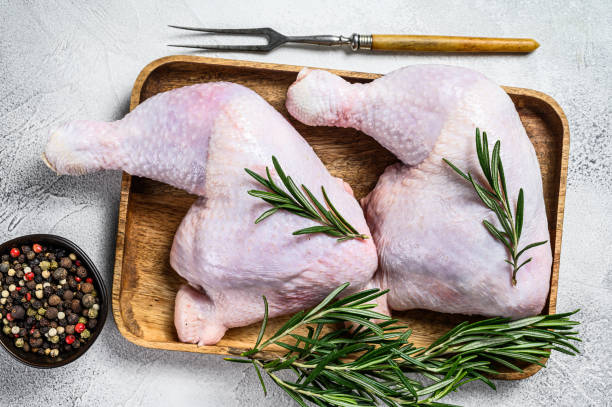 istock Raw chicken legs on a cutting board. White background. Top view 1311052178