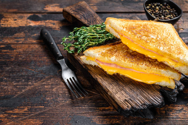 istock Fried ham and melted cheese sandwich. Dark wooden background. Top view. Copy space 1311053393