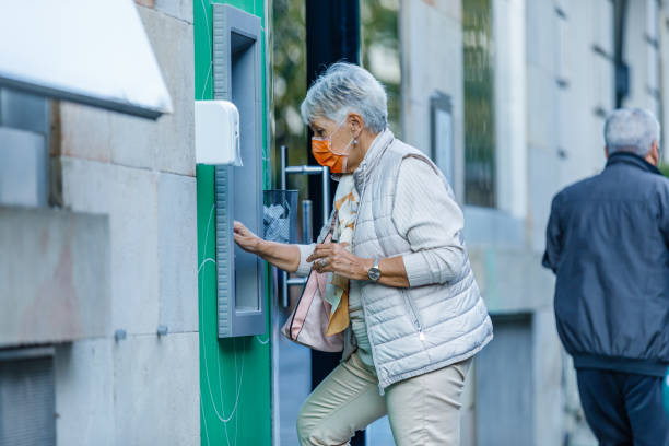 istock Senior Woman is Using ATM During a Pandemic Time. 1311056523
