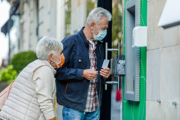 istock Senior Couple is Using ATM During a Pandemic Time. 1311057435