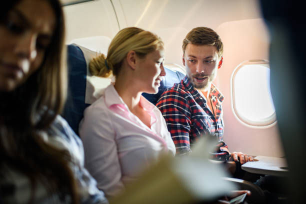 istock Young couple communicating while traveling by airplane. 1311058817