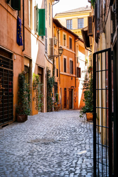 A lovely and ancient alley in the heart of the Jewish Ghetto in downtown Rome A lovely and ancient alley in the Jewish Quarter of Rome (Roman Ghetto). This iconic quarter of Rome, the oldest Ghetto in Europe, is constantly visited by tourists due to the presence of hidden alleys and small squares, where it is easy to find restaurants of Italian and Jewish cuisine and notable Roman archaeological remains. Image in High Definition format. narrow photos stock pictures, royalty-free photos & images