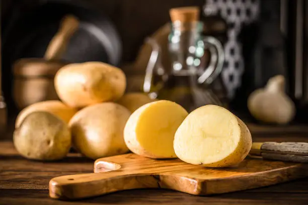 Photo of Sliced raw potato on a rustic kitchen