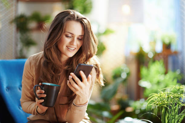 istock smiling stylish woman in sunny day using phone app 1311059366