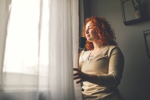 istock Enjoying the smell of coffee while looking out through the window 1311060546