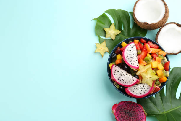 istock Flat lay composition with delicious exotic fruit salad on turquoise background. Space for text 1311062433