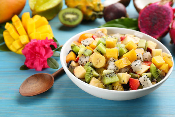 istock Delicious exotic fruit salad on light blue wooden table 1311062581