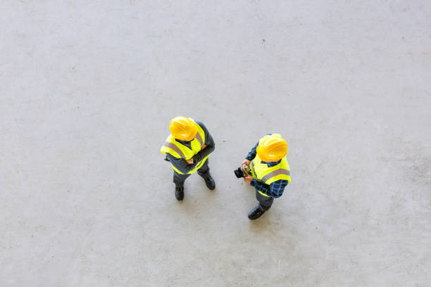vue à angle élevé des ouvriers de construction - inspector safety construction reflective clothing photos et images de collection