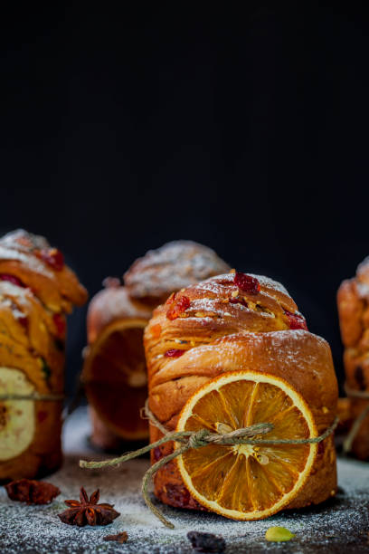 istock Easter cake Kraffin (Cruffin), with nuts and candied fruit sprinkled with powdered sugar on a black background, 2021 trend of the easter cake 1311064558