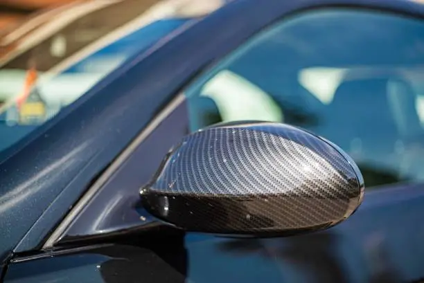 Detail of the rearview mirror in carbon fiber of the car tuning
