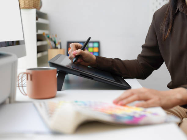istock Female graphic designer hands working with drawing tablet and colour swatch 1311066555