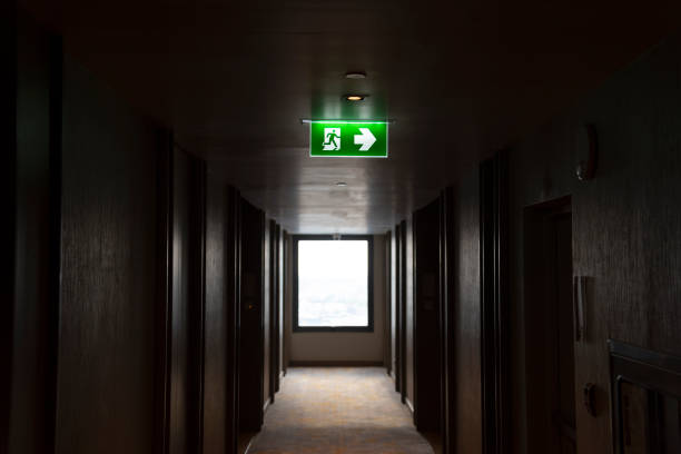 Illuminated green light emergency exit sign in public building for emergency accident and fire case