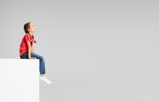 Girl in a white dress and in a white photo studio