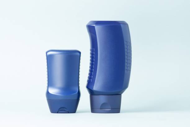 istock Two blue plastic bottles of cosmetics on a blue background. 1311068568