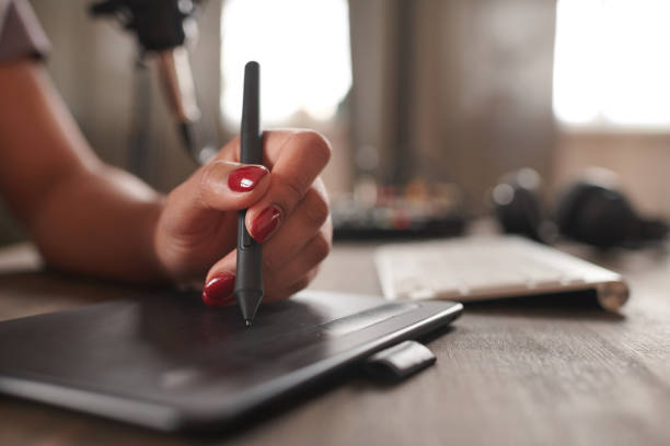 Closeup Of Stylus Tip In Front Of Blurred Blue Screens, Showing Touchscreen Writing And Precision Input For Digital Notes, Drawing, Editing, And Creative Tablet Work.