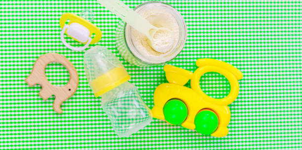 istock Baby accessories and food on a green background. Selective focus. 1311069715